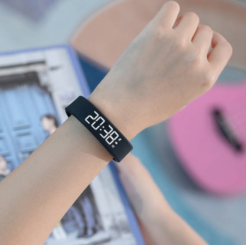 Black digital wristband on a wrist with a blurred background